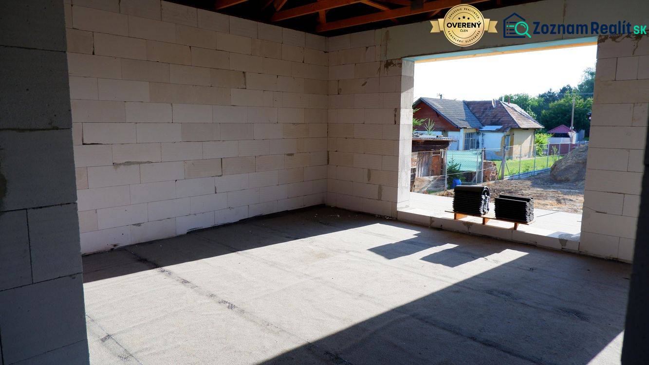 Ponúkame na predaj štvorizbový rodinný dom v obci Radava. - Výstavba rodinného domu v Radave s pohľadom na neomietnuté steny a okolitú krajinu.