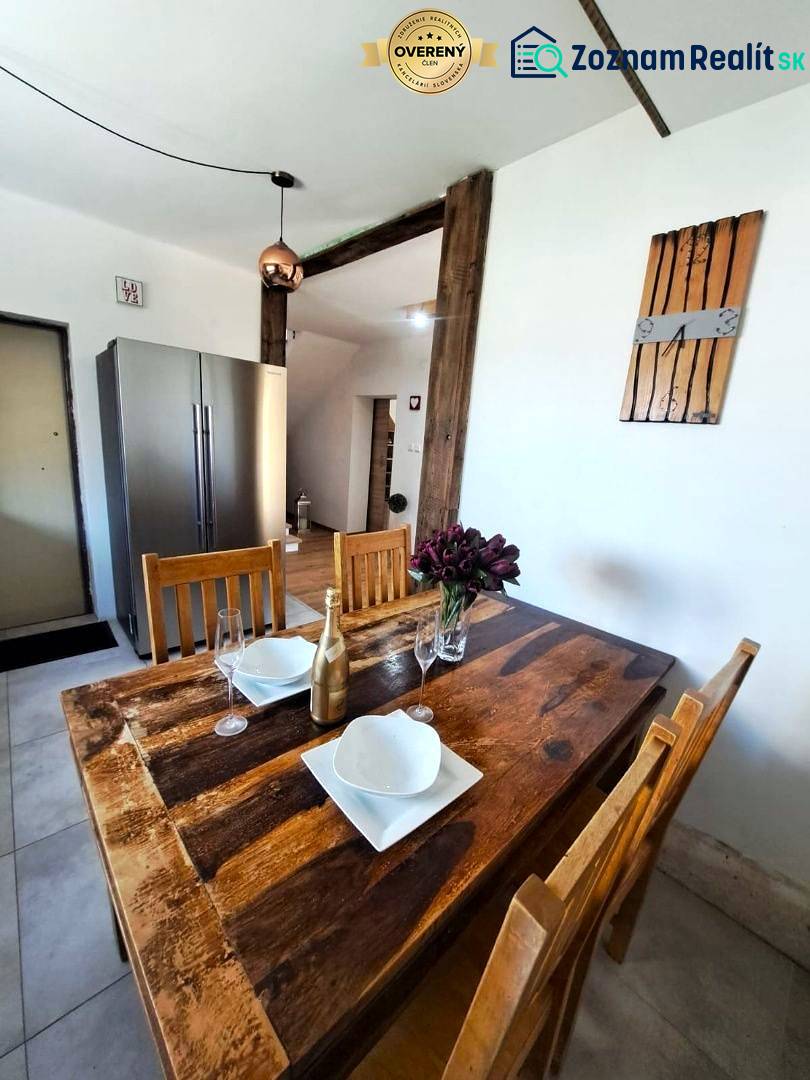 Exkluzívne na predaj 5 izbový rodinný dom - Jedálenský stôl s doplnkami a chladnička v kuchyni rodinného domu.