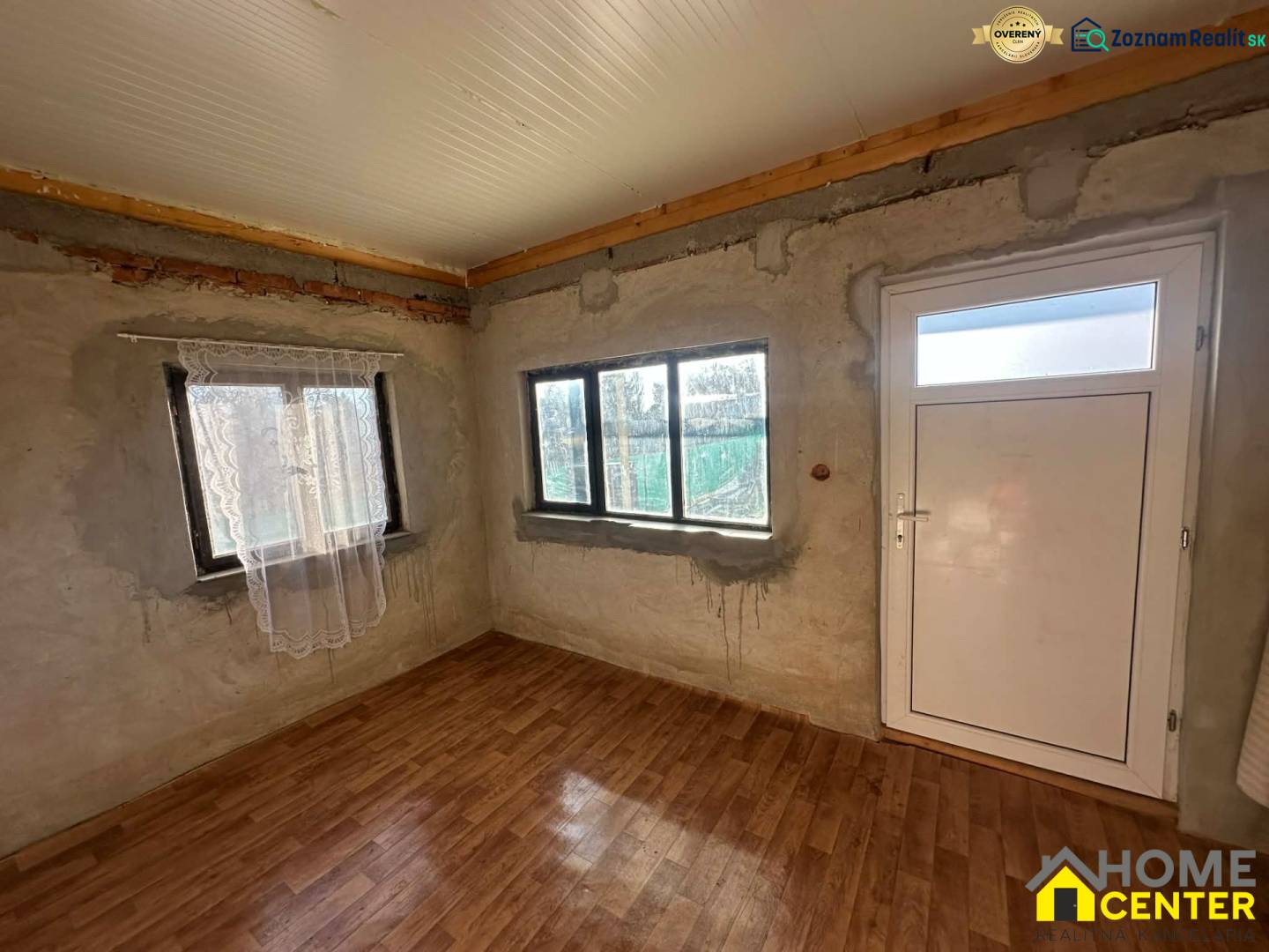 PREDAJ : ZÁHRADA S MUROVANOU CHATKOU, KOMÁRNO - Interiér s podlahou s dreveným dekorom a bielymi dverami v časti Záhrady.