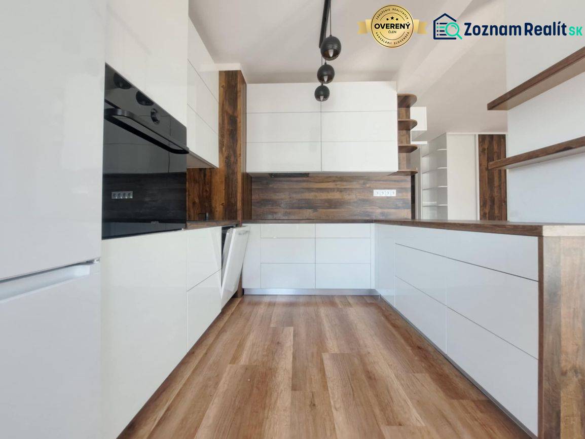REZERVOVANÝ! Nová cena! Moderný 2-izbový byt – Galanta, sídlisko West - Kuchyňa v 2-izbovom byte s bielymi skrinkami a podlahou s dreveným dekorom.