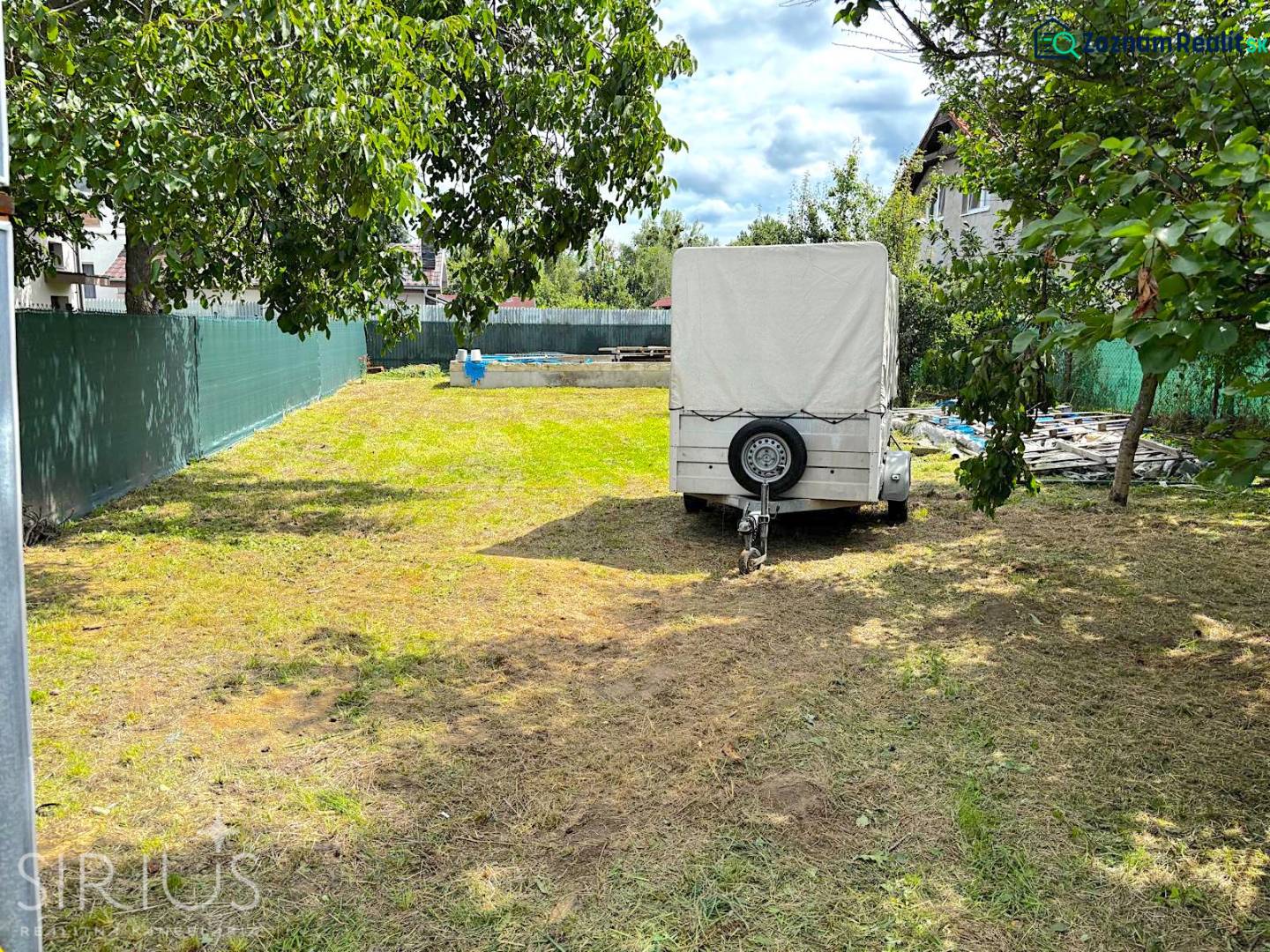 IVANKA PRI DUNAJI, stavebný pozemok 447 m2 s vydaným SP, pôvodná časť - Záhrada s prívesom obklopená stromami na pozemku v Ivanke pri Dunaji, ulica Ivanak pri Dunaji.