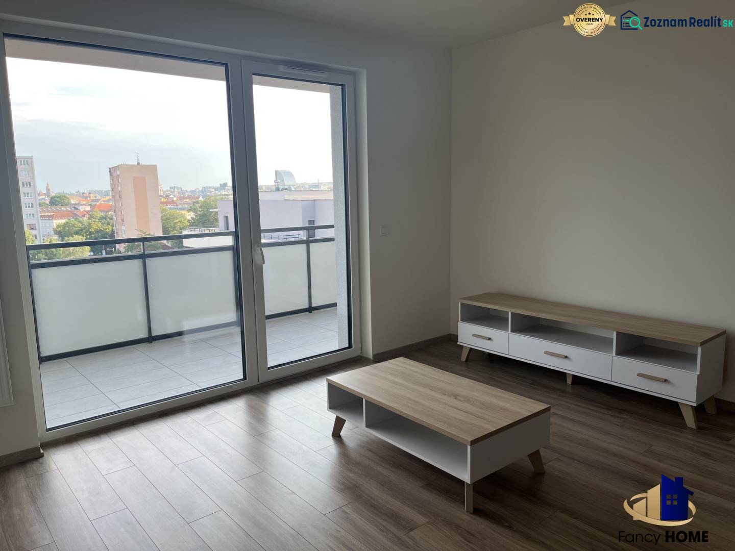 2 izbový byt na prenájom v centre Košíc  - Obývacia miestnosť v 2-izbovom byte s podlahou s dreveným dekorom a veľkým balkónovým oknom.