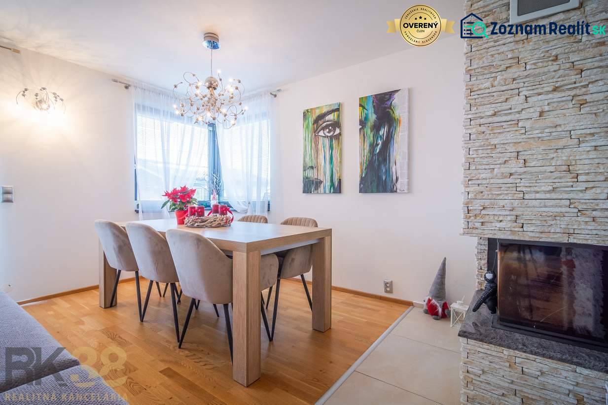 Výhodná cena: Rodinný dom v tichej lokalite v obci Spišské Bystré - Jedáleň v rodinnom dome s podlahou s dreveným dekorom, krbom a nástenným umením.