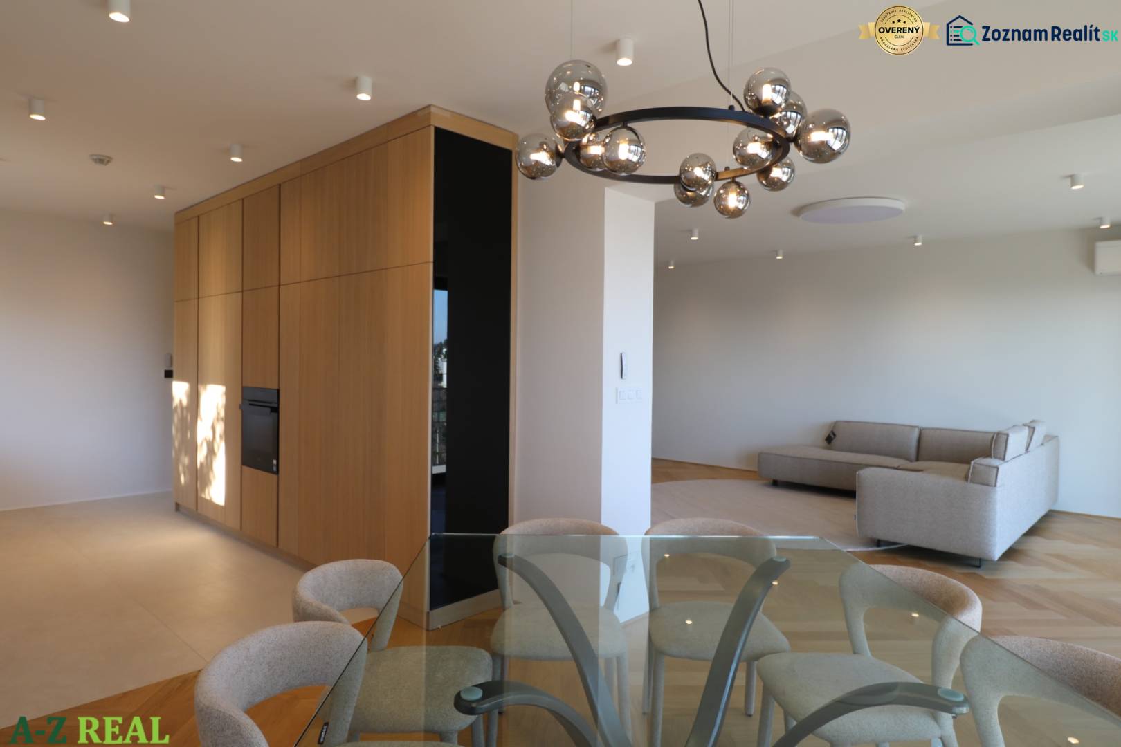 Prenájom 4 izbového bytu s krásnym výhľadom na mesto - Interiér 4-izbového bytu s pohovkou, skleneným stolom a podlahou s dreveným dekorom.