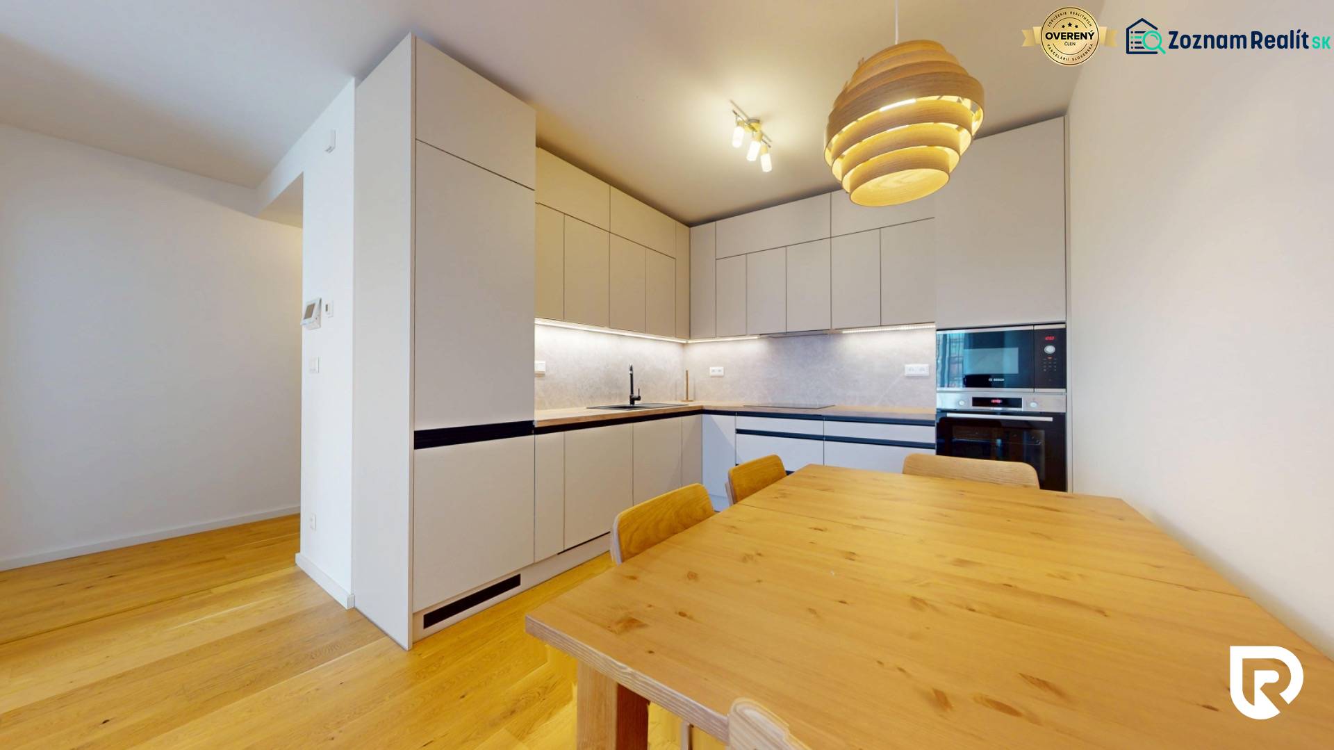 | Prémiové bývanie v ZWIRNe I Pekný zariadený 2i byt I  - Kuchyňa v 2-izbovom byte, podlaha s dreveným dekorom, jedálenský stôl, biele skrinky.