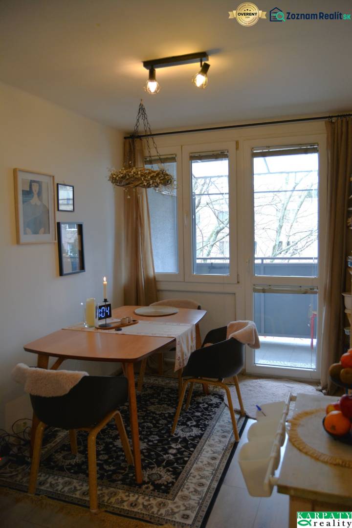 Útulný 3-izbový byt v Trnave na skok do Kamenáča! - Jedálenský kút v 3-izbovom byte s kobercovým dekorom a prosklenými dverami na balkón.