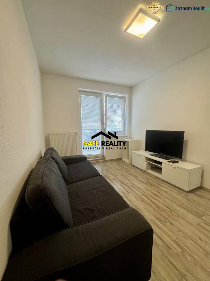 PRENÁJOM 2-izbový byt, Žilina - Slnečné terasy - Obývacia izba v 2-izbovom byte s pohovkou, televízorom a podlahou s dreveným dekorom.