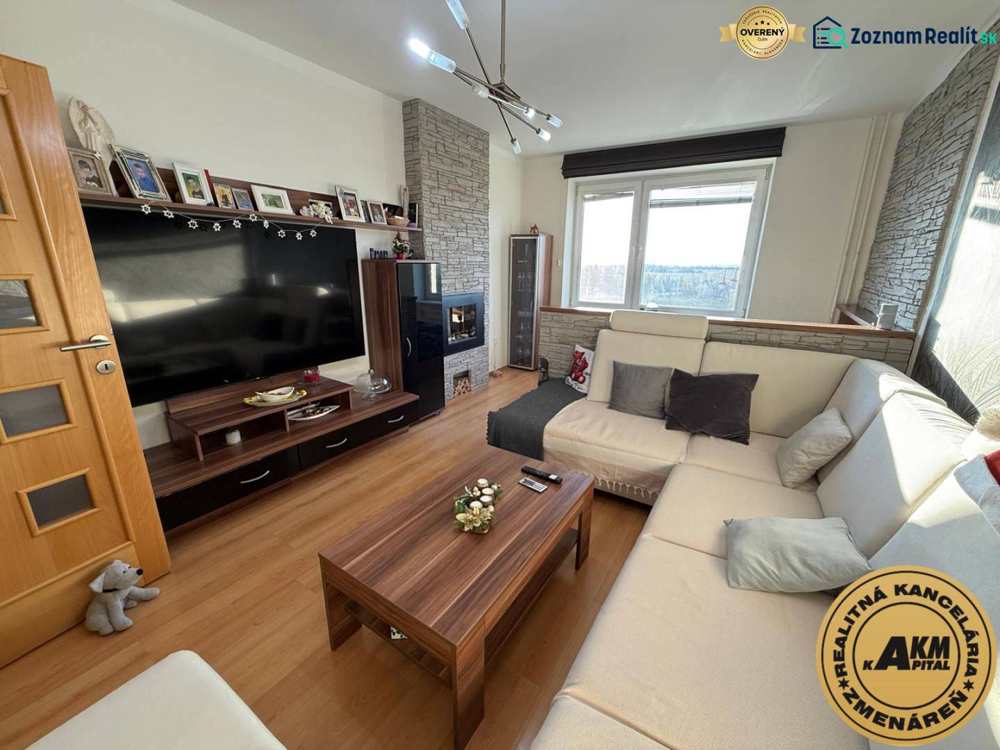 3 izbový byt 83 m² 2x balkón  Žiar nad Hronom centrum na predaj  - Obývacia izba v 3-izbovom byte s komfortnou sedačkou, podlahou s dreveným dekorom a televízorom.