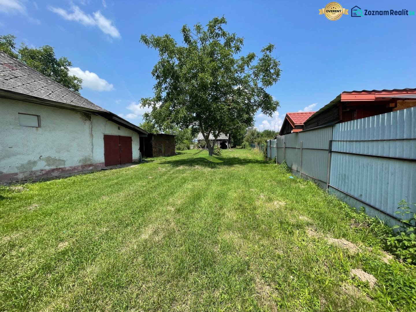 Super pozemok pre rodinný dom blízko mesta - Výhľad na zelený pozemok v Zemplínskej Širokej, ideálny na bývanie, s viditeľnými budovami.