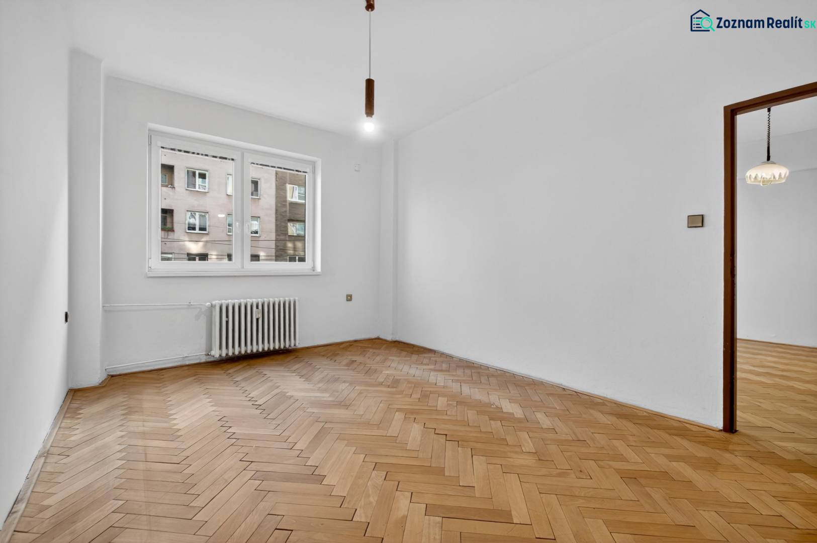 I PREDAJ Priestranný 3-izb. byt v centre Krížna/Blumentálska - Izba s podlahou s dreveným dekorom a radiátorom v 3-izbovom byte.