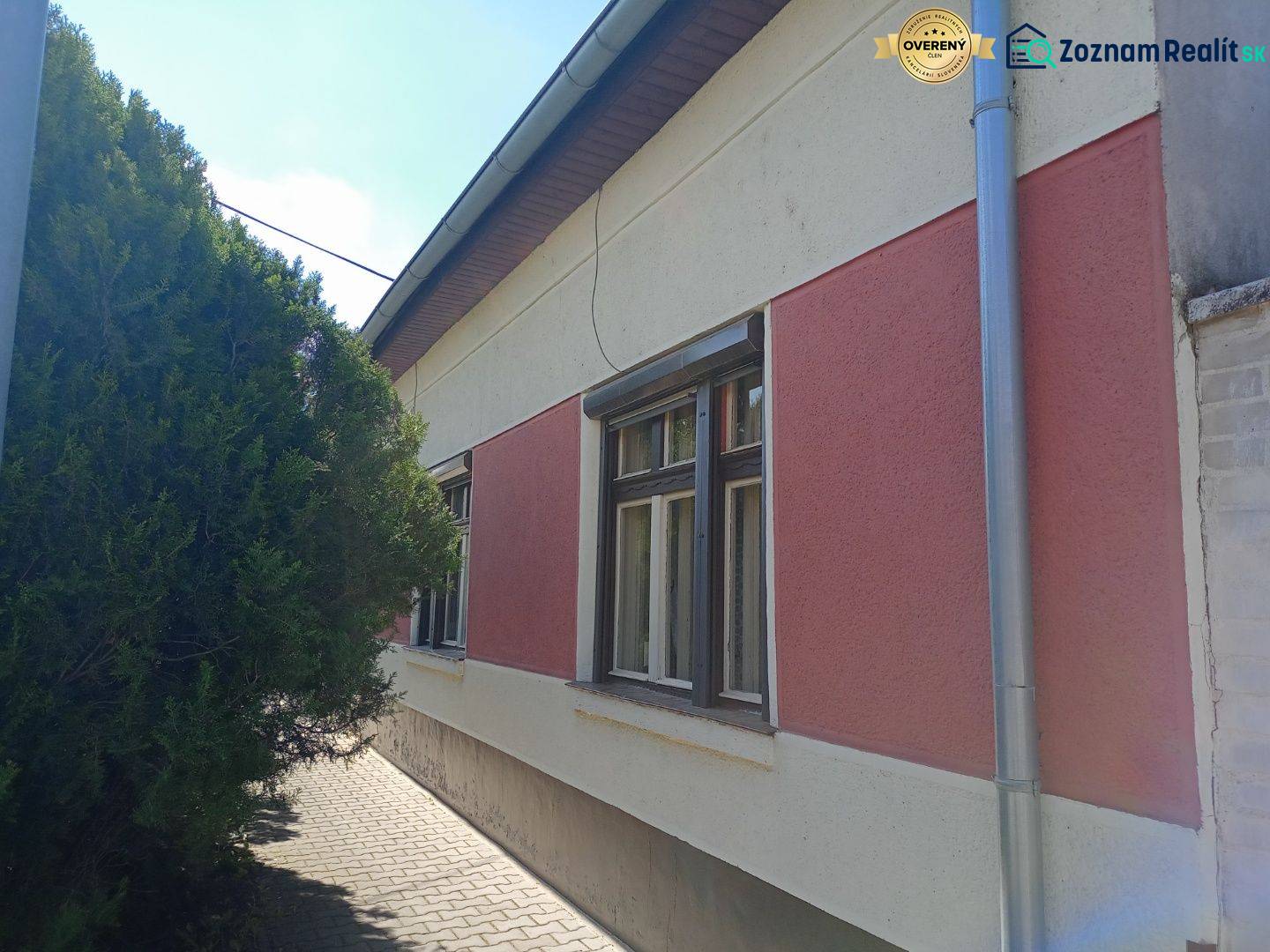 Na predaj rodinný dom v super lokalite - Rodinný dom v Nových Zámkoch so sieťami na zateplenej fasáde a stromom pri chodníku.