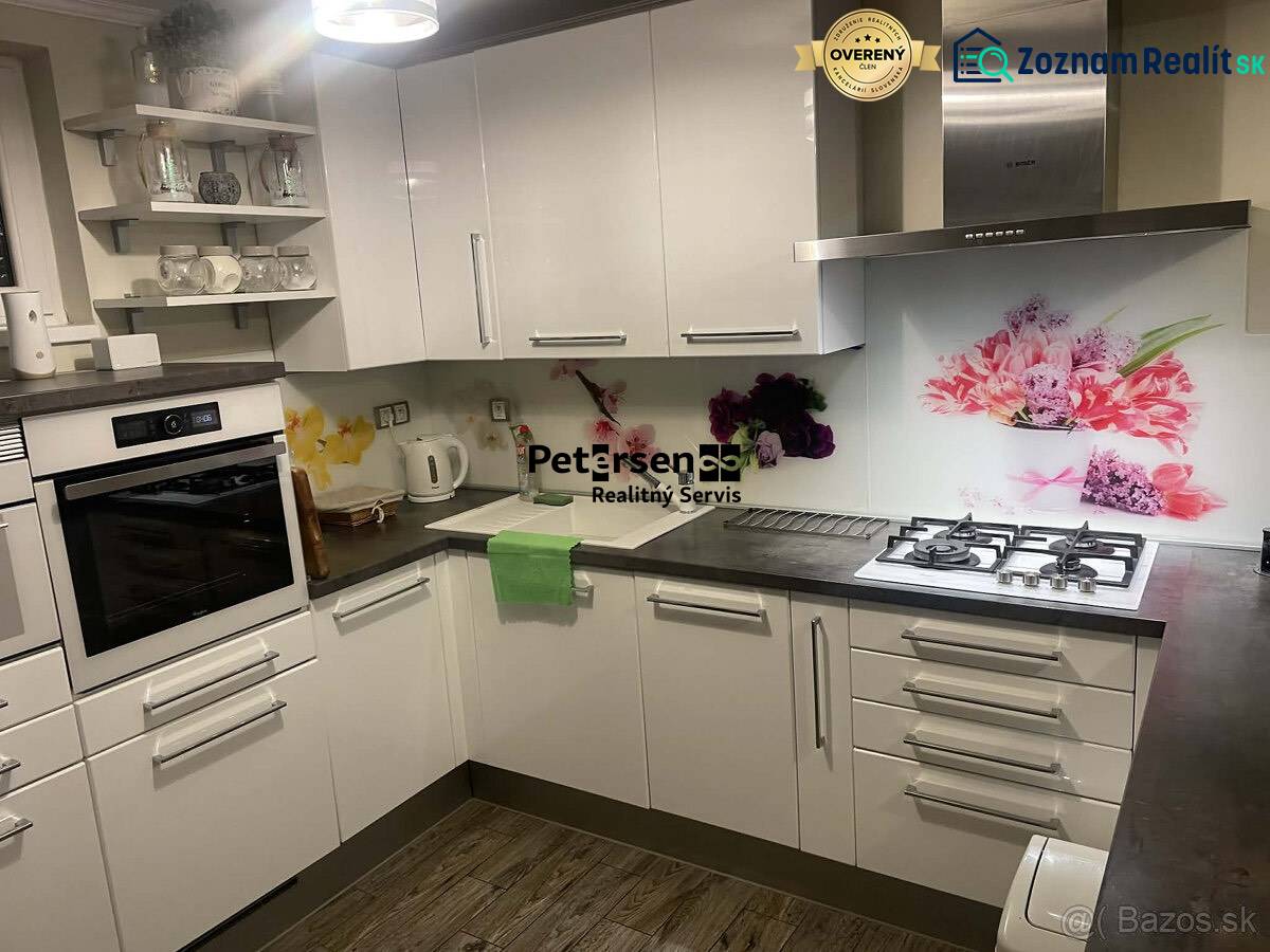 KRÁSNY DVOJPODLAŽNÝ RODINNÝ DOM NA PRENÁJOM - Kuchyňa v Rodinnom dome s bielymi skrinkami, dekoratívnym obkladom a podlahou s dreveným dekorom.