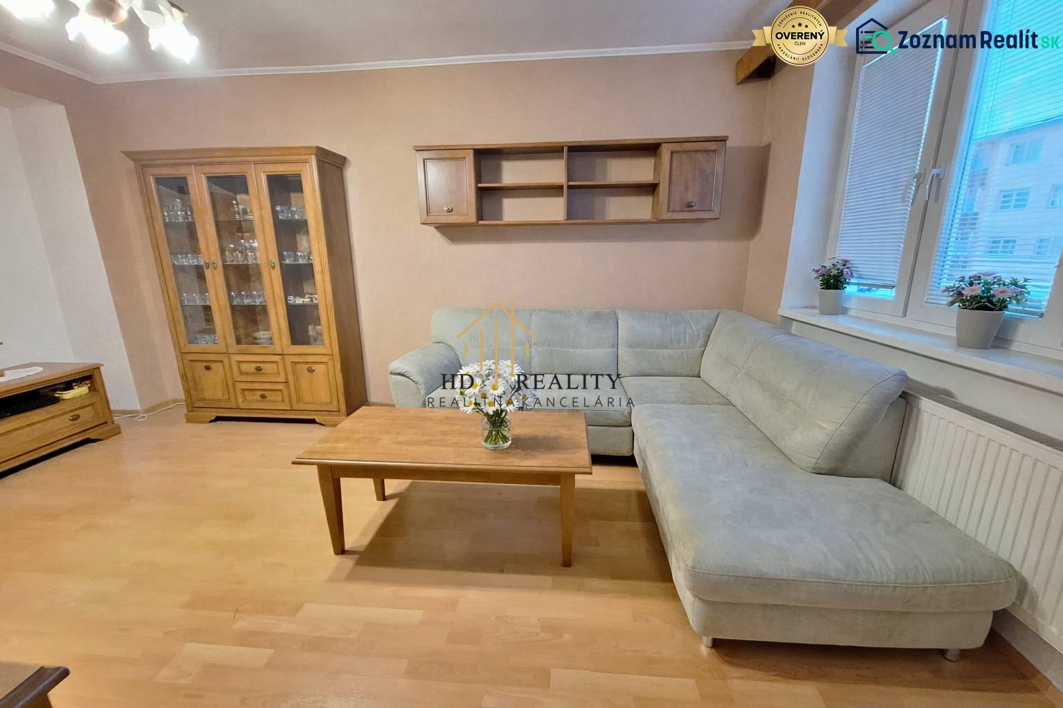 Predaj 2 izbový byt s dvoma balkónmi v Nižnej. - Obývačka v 2-izbovom byte s rohovou sedačkou, drevený dekor dopĺňa interiér.