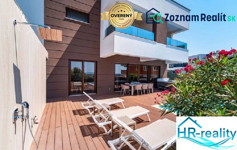 Novalja – luxusná vila s bazénom, jacuzzi a výhľadom na more - Terasa s ležadlami pri vile v Novalji s výhľadom na more a sprchou.