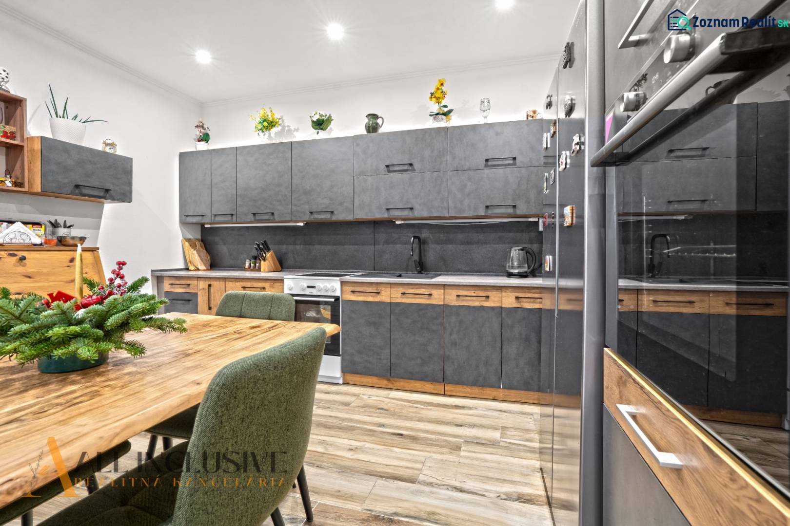 NA PREDAJ 4-IZBOVÝ RODINNÝ DOM V KOLÁROVE - Kuchyňa rodinného domu s podlahou s dreveným dekorom a šedým nábytkom.