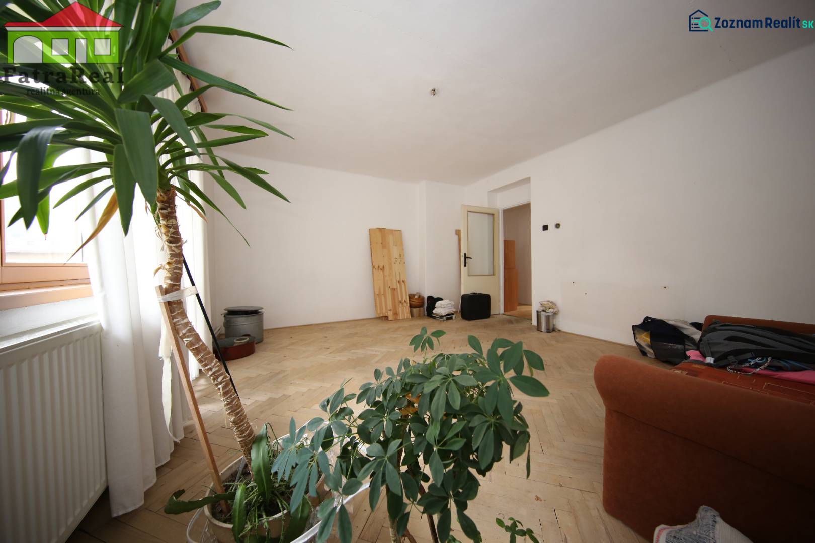 3-izb. byt v rekonštrukcii, Ľubochňa okres Ružomberok - Svetlá miestnosť v 3-izbovom byte s podlahou s dreveným dekorom a izbovými rastlinami.