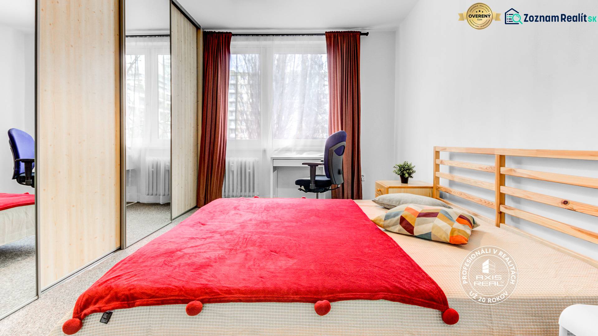 Zariadený 2-izbový byt, DVE NEPRIECHODNÉ IZBY, OC RETRO - Spálňa v 2-izbovom byte s červeným prehozom, skriňou a stolom.
