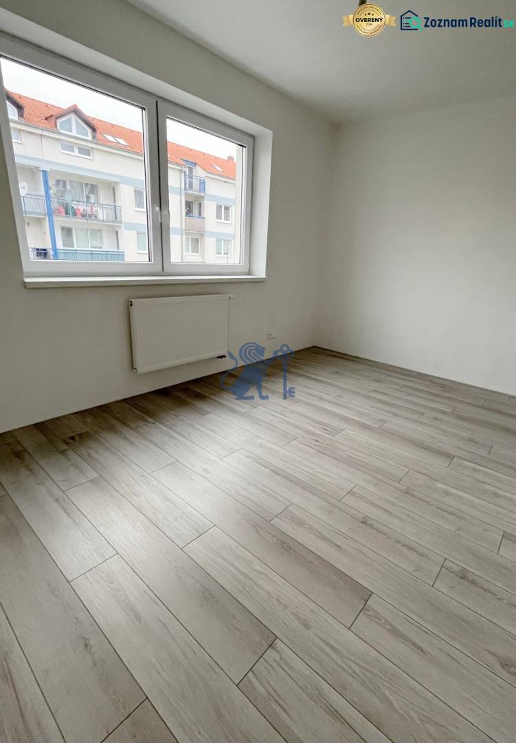 Na predaj 2 izb. byt s balkónom blízko centra, Chorvátsky Grob - Izba s podlahou s dreveným dekorom a veľkým oknom v 2-izbovom byte.