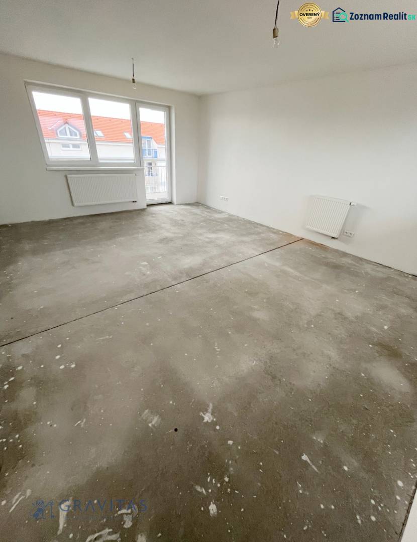 Na predaj 3 izb. byt s balkónom blízko centra, Chorvátsky Grob - Prázdna miestnosť v 3-izbovom byte so základnou podlahou a bielymi stenami.