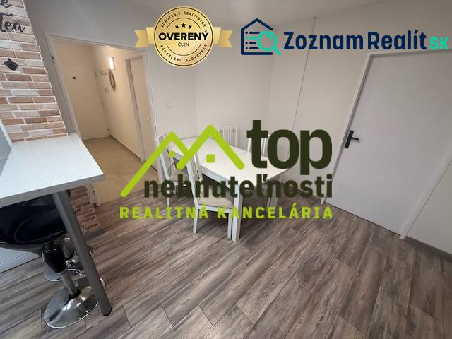 TOPOĽČANY Priestranný 1-izbový byt na prenájom 60 m2 - Jedálenský kút v 1-izbovom byte s podlahou s dreveným dekorom a barovou stoličkou.