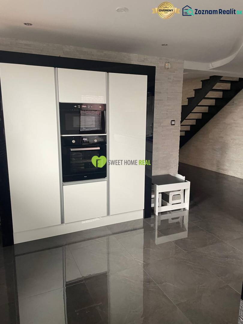 Moderný zariadený rodinný dom na prenájom 120m2 s terasou Košice Barca - Kuchyňa v rodinnom dome s lesklou čiernou podlahou a bielymi spotrebičmi.