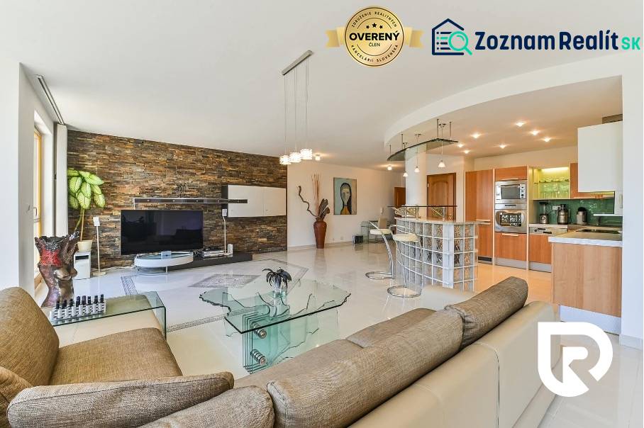 Staré Mesto | 5i byt 175 m² + 4 balkóny + možnosť 2× parking - Priestranný obývací priestor s kuchyňou, skleneným stolíkom a kamennou stenou v 4-izbovom byte.