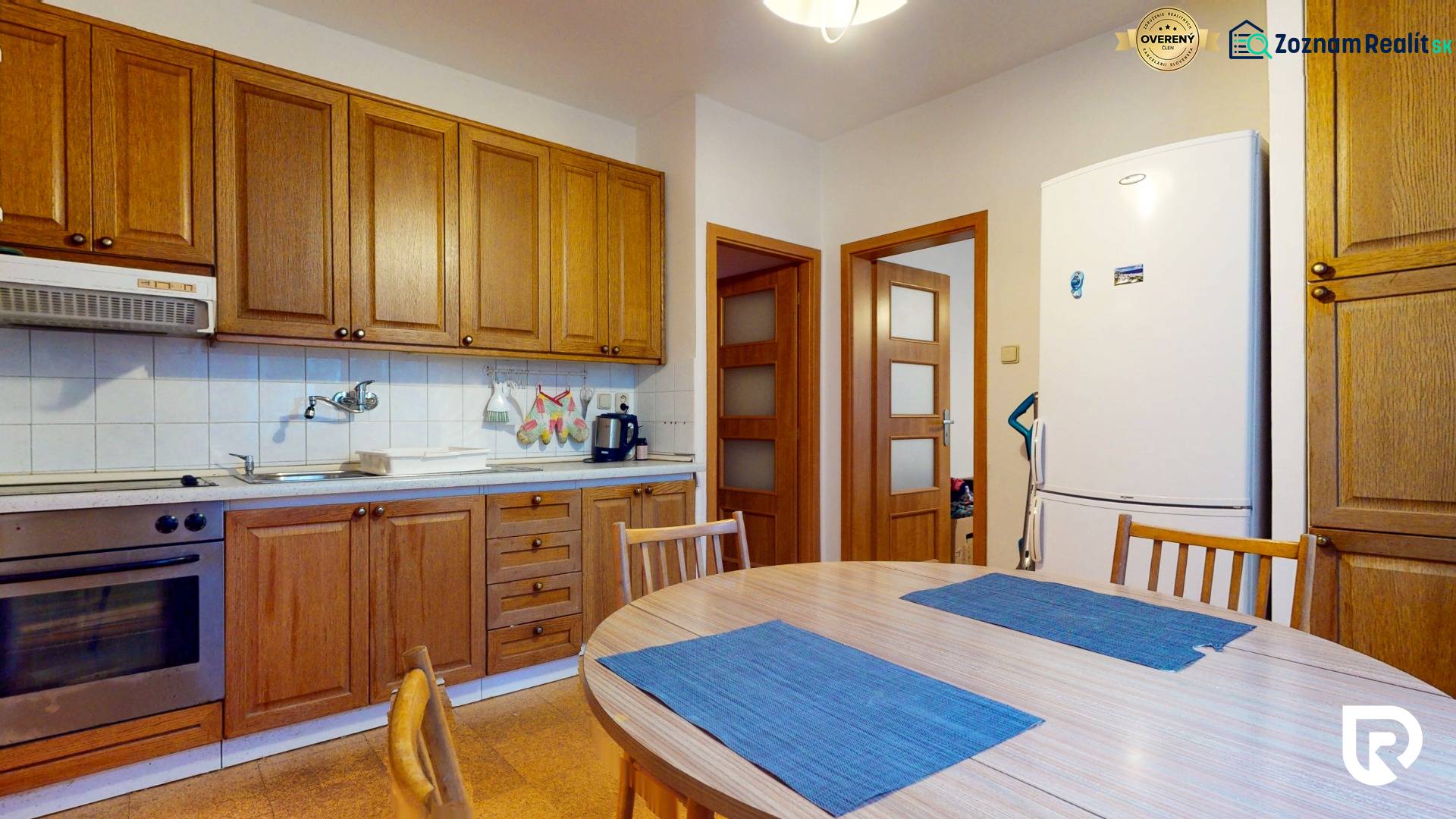 Veľkometrážny 3i byt s výťahom a pivnicou | Ružinov | 82m2 - Kuchyňa v 3-izbovom byte s drevenými skrinkami a jedálenským stolom.