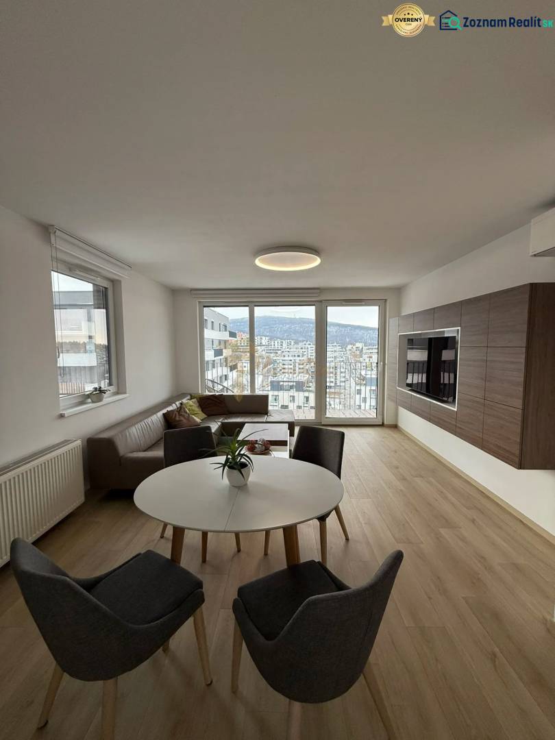 3-izb. byt, Martina Granca, Dúbravka, novostavba Pekná výhliadka - Obývačka v 3-izbovom byte s výhľadom, svetlou podlahou s dreveným dekorom a sedením.
