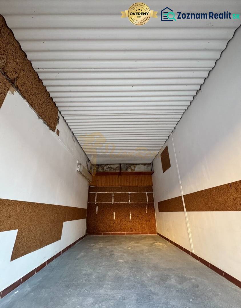 Garáž Bebravská ul., Vrakuňa s pozemkom - Interiér garáže s bielym stropom a hnedými stenami v lokalite Bebravská, Bratislava - Vrakuňa.