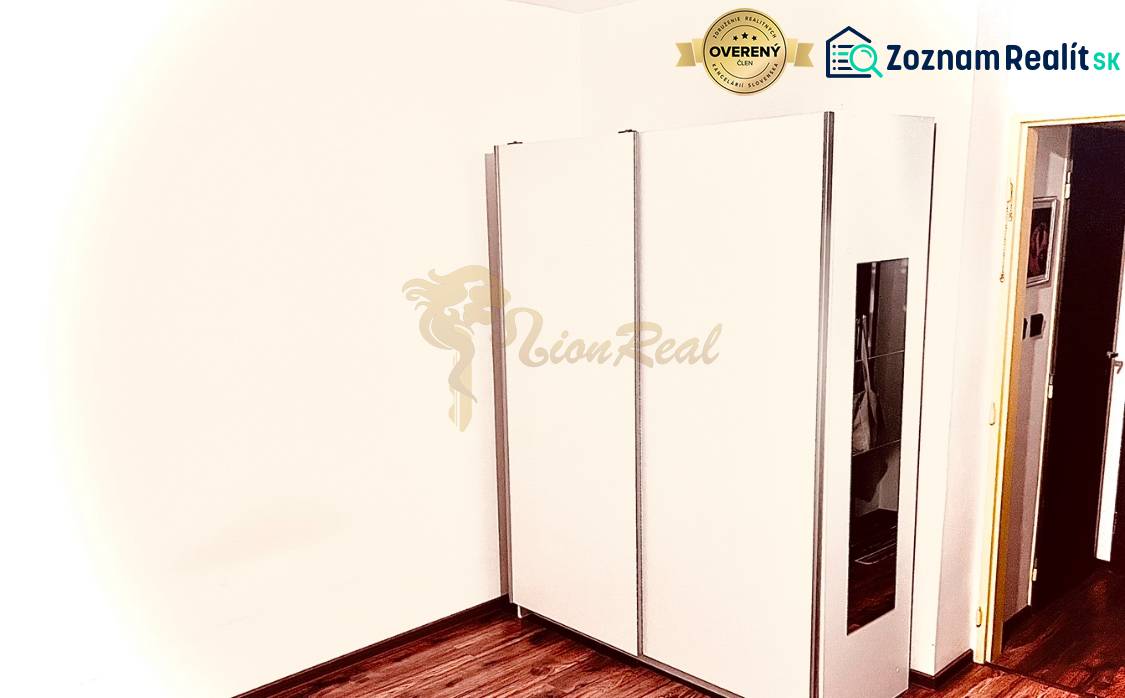 Garzónka M. Schneidra Trnavského, Dúbravka, veľká lodžia - V garsónke je umiestnená biela vstavaná skriňa a podlaha s dreveným dekorom.