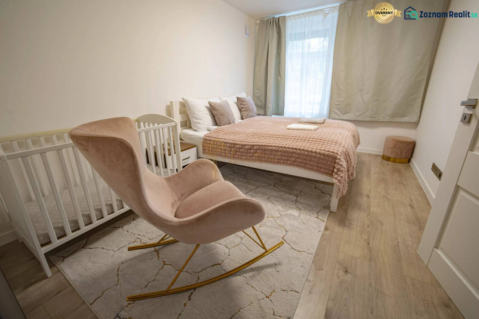 2,5 izb. byt, ul. Jelenia, Staré Mesto,tehlový dom, po rekonštrukcii - Spálňa s posteľou, drevenou podlahou, detskou postieľkou a hojdacím kreslom, na ulici Jelenia.