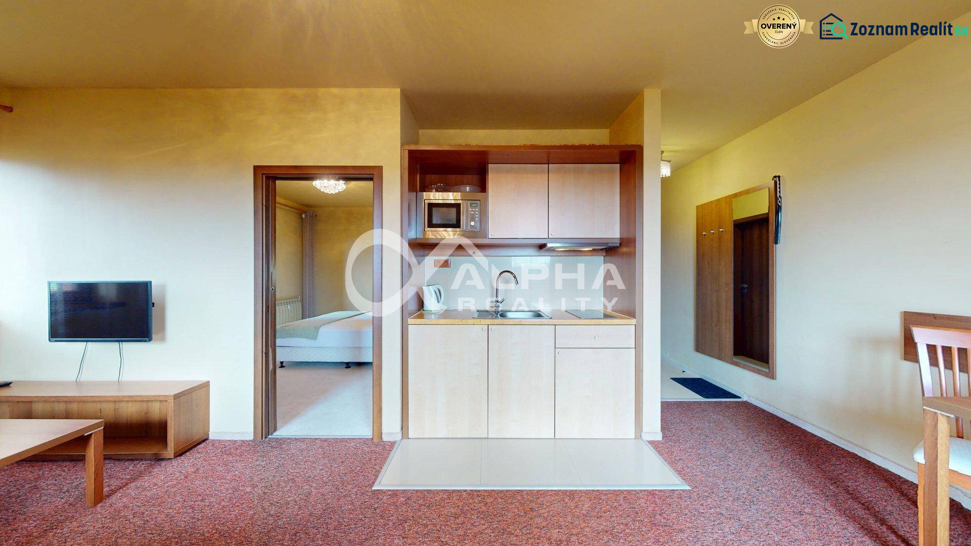 EXKLUZÍVNE 2i apartmán s terasou, garážovým státím, Veľká Lomnica - Kuchynka v 2-izbovom byte zahŕňa umývadlo, mikrovlnku a televízor na stene.