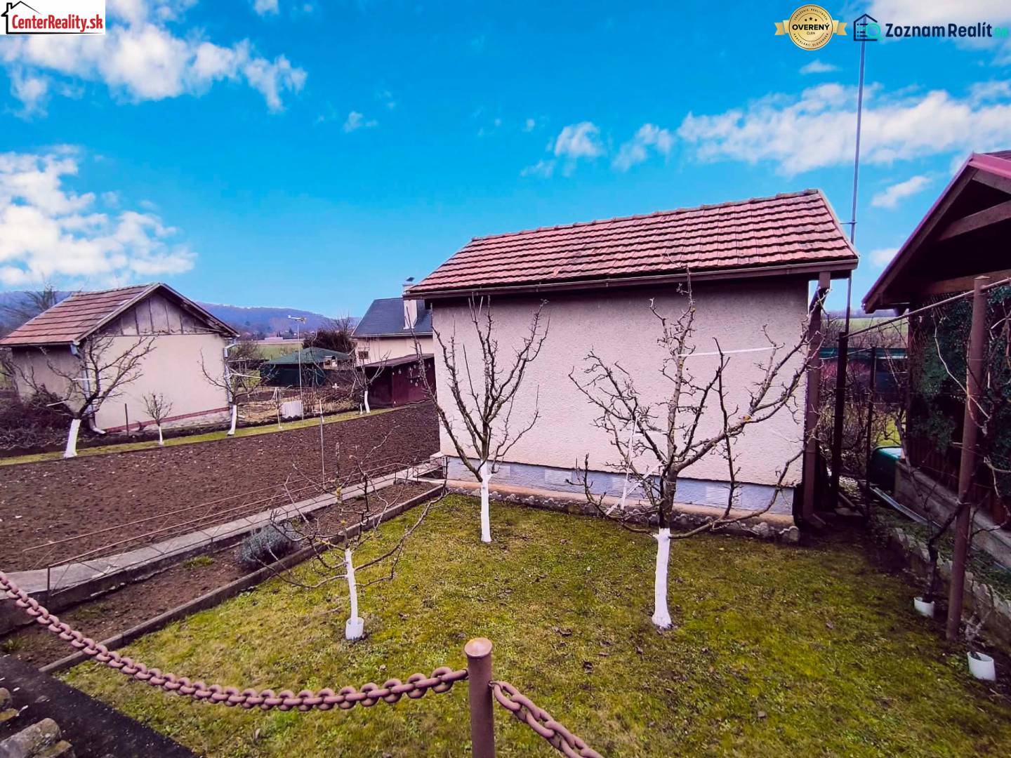 ‼️BRODZANY - ZÁHRADA S MUROVANOU CHATKOU NA PREDAJ, okr. PARTIZÁNSKE‼️ - Záhrada s chatou v Partizánskom, ovocné stromy a obrábaná pôda, jasná obloha.