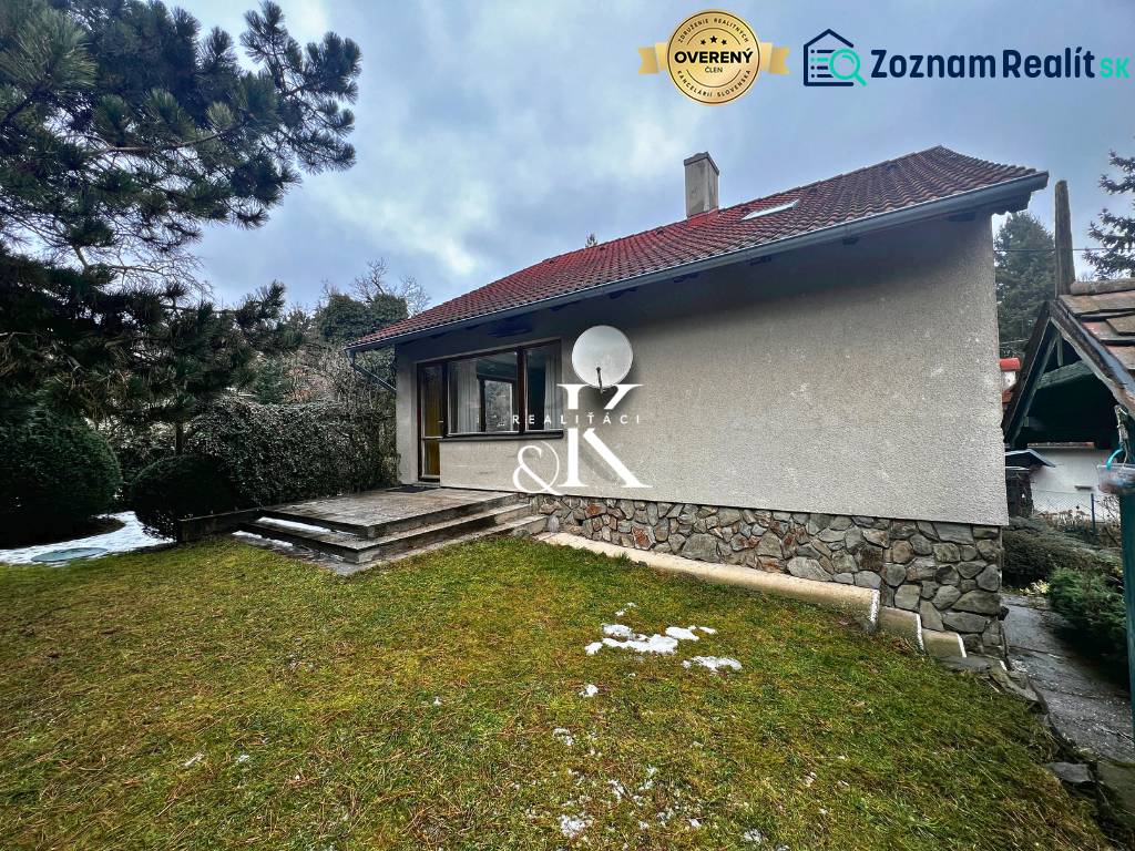 Predaj rekreačná chata s pozemkom, garážou a saunou Modra, Harmónia - Chata pri Modre s trávnatým pozemkom, kamennými schodmi a ihličnatými stromami.