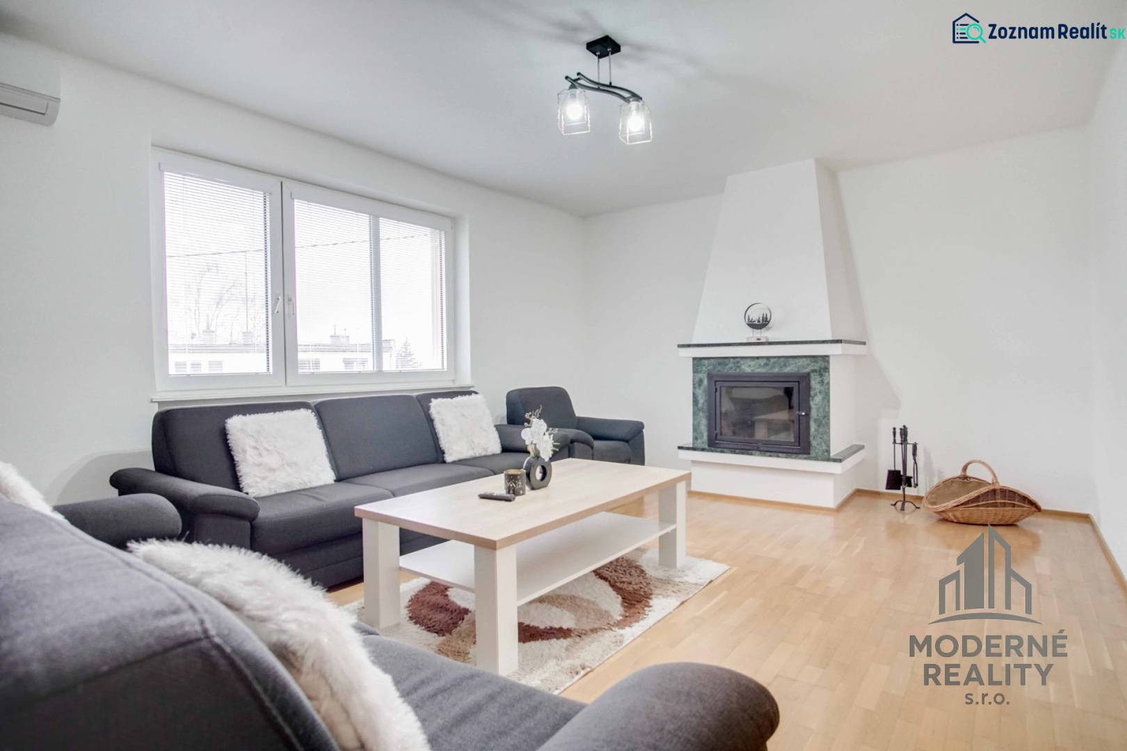 Na prenájom veľký 4-izbový byt s balkónom, garážou a záhradou, Kolta – - Obývacia izba v 4-izbovom byte s krbom a podlahou s dreveným dekorom.