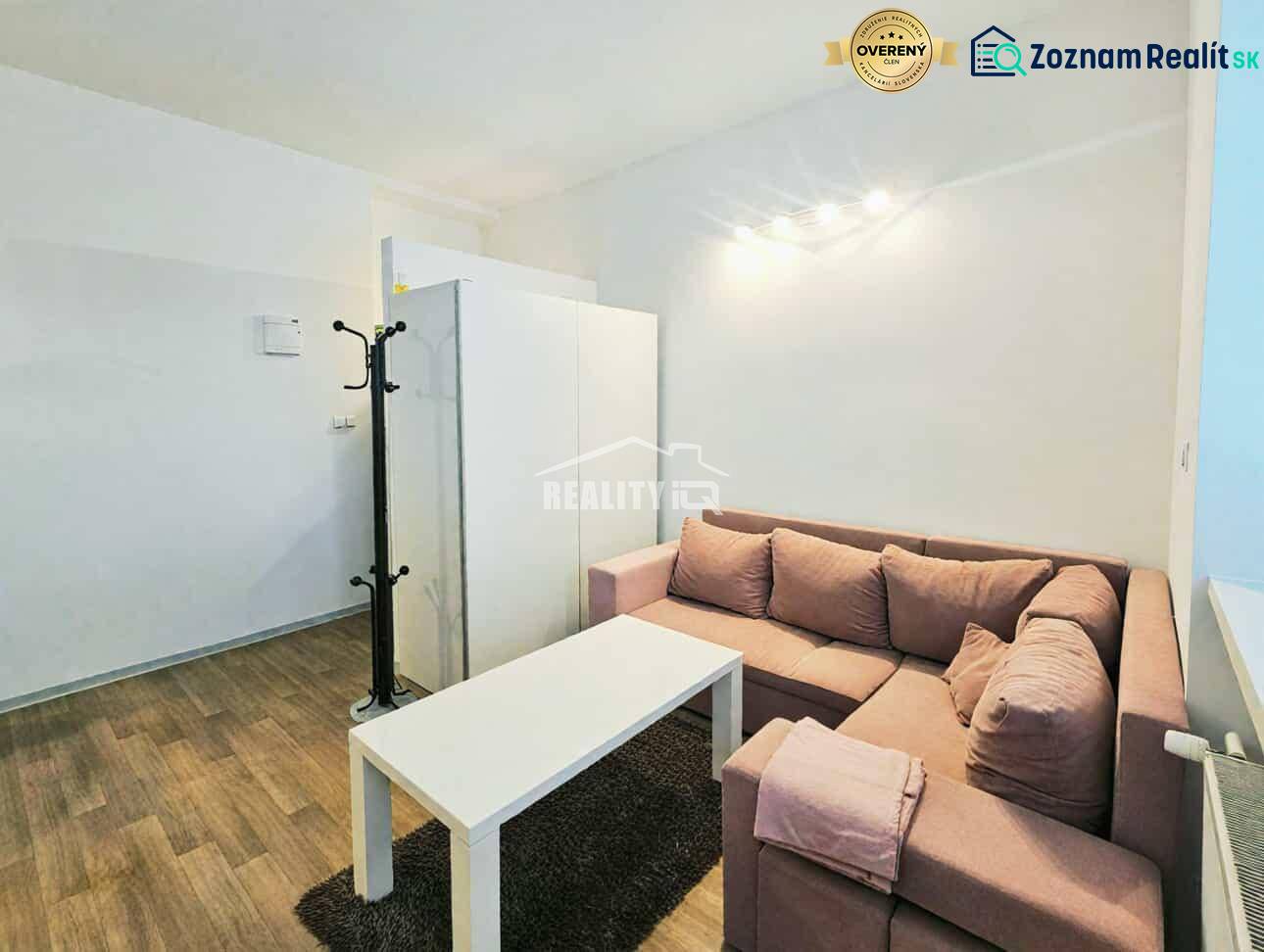 Prenájom, Garsónka, M.R.Štefánika, Centrum, Žilina - Garsónka s rohovou sedačkou, bielym stolíkom a podlahou s dreveným dekorom.