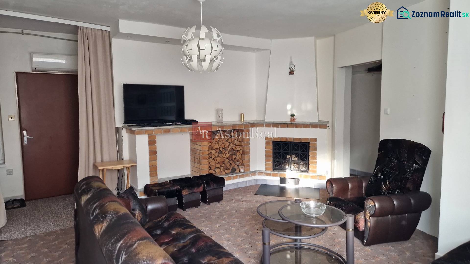 AstonReal: EXKLUZÍVNE predaj rodinný dom Spišská Nová Ves - Ferčekovce - Obývacia izba s kozubom v rodinnom dome, kožené kreslo a konferenčný stolík.