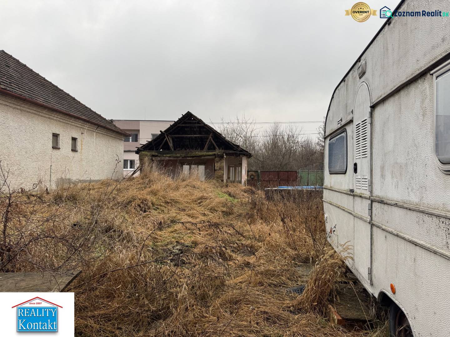 Predám pozemok v obci Dubník okr. Nové Zámky - Dvor v Dubníku na ulici Dubník vhodný na pozemky - bývanie s pohľadom na budovy a karavan.