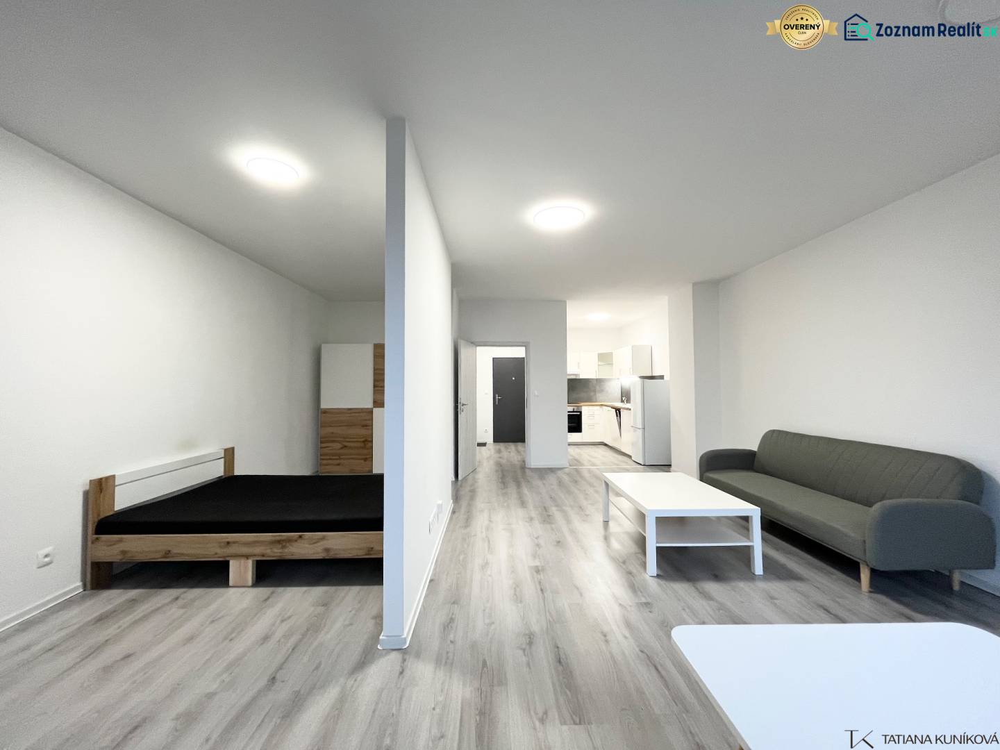 NA PRENÁJOM! Veľkometrážny 56m2 1i byt, Veľkomoravská, Trenčín - Interiér 1-izbového bytu s podlahou s dreveným dekorom, posteľou a pohovkou.