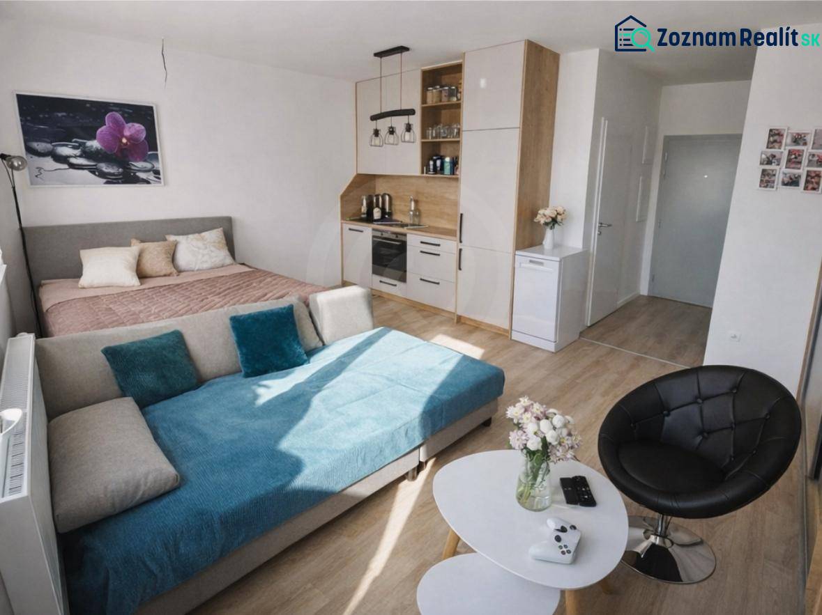 Zariadený 1 – izbový byt - 39 m², Tri veže. - 1-izbový byt s posteľou, gaučom, kuchynskou linkou a podlahou s dreveným dekorom.