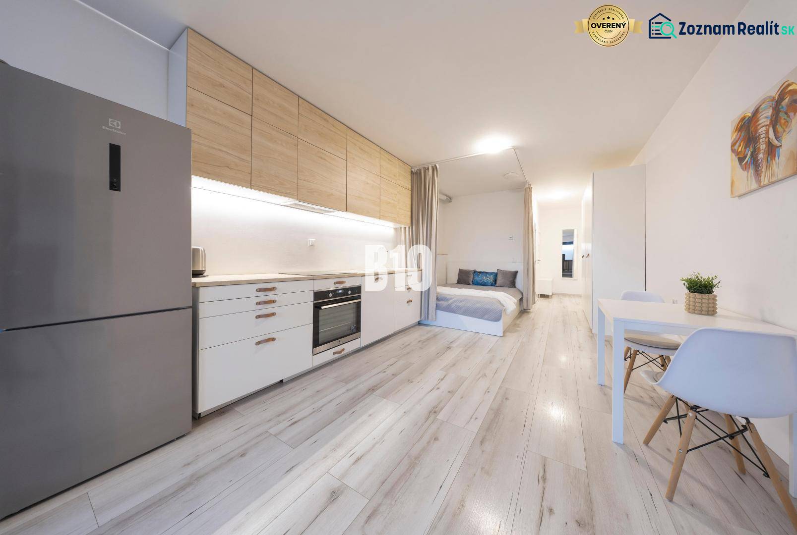 TEHELNÉ POLE | 1-izbový byt s priestrannou terasou - Kuchyňa v 1-izbovom byte s podlahou s dreveným dekorom a jedálenským stolom.