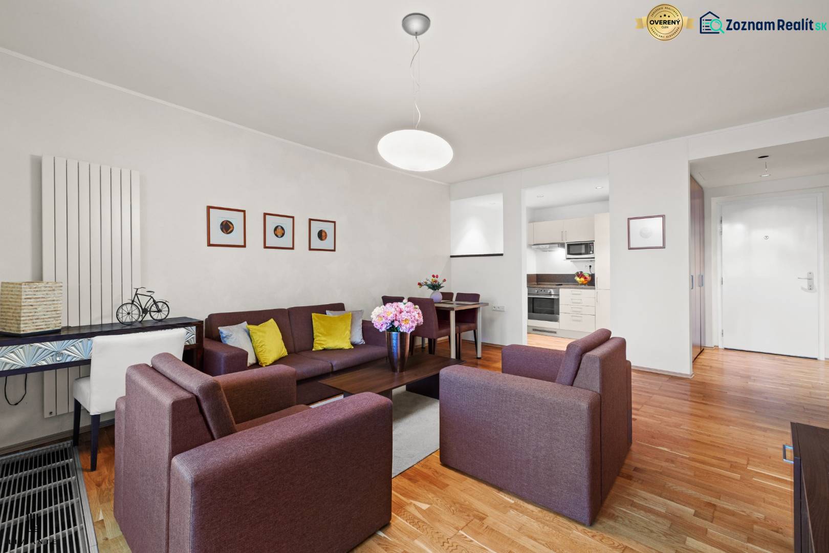 PRENÁJOM - reprezentatívny 2i byt v RIVER PARKU, ideálny aj na firmu - Obývačka v 2-izbovom byte s podlahou s dreveným dekorom, pohodlnými sedačkami a kuchynským kútom.