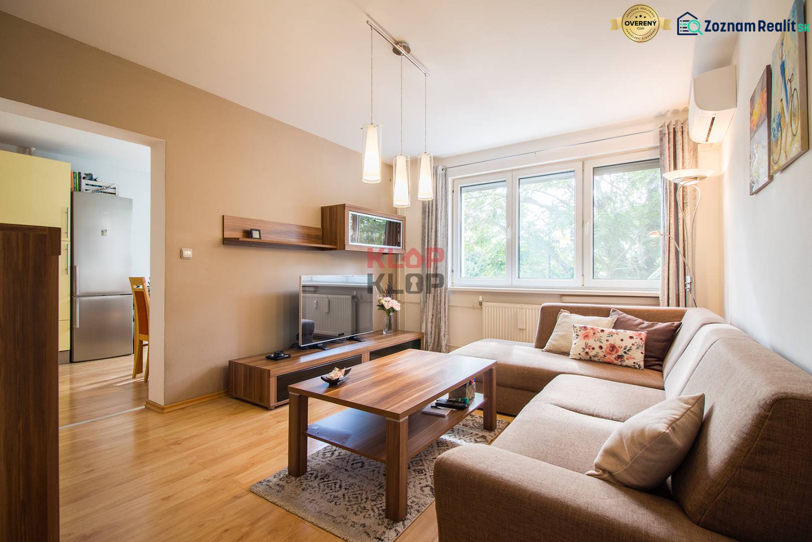 Pozrite si PRÍJEMNÝ 2i byt so ZARIADENÍM, LODŽIOU a KLIMATIZÁCIOU - Obývacia izba v 2-izbovom byte s pohovkou a podlahou s dreveným dekorom.