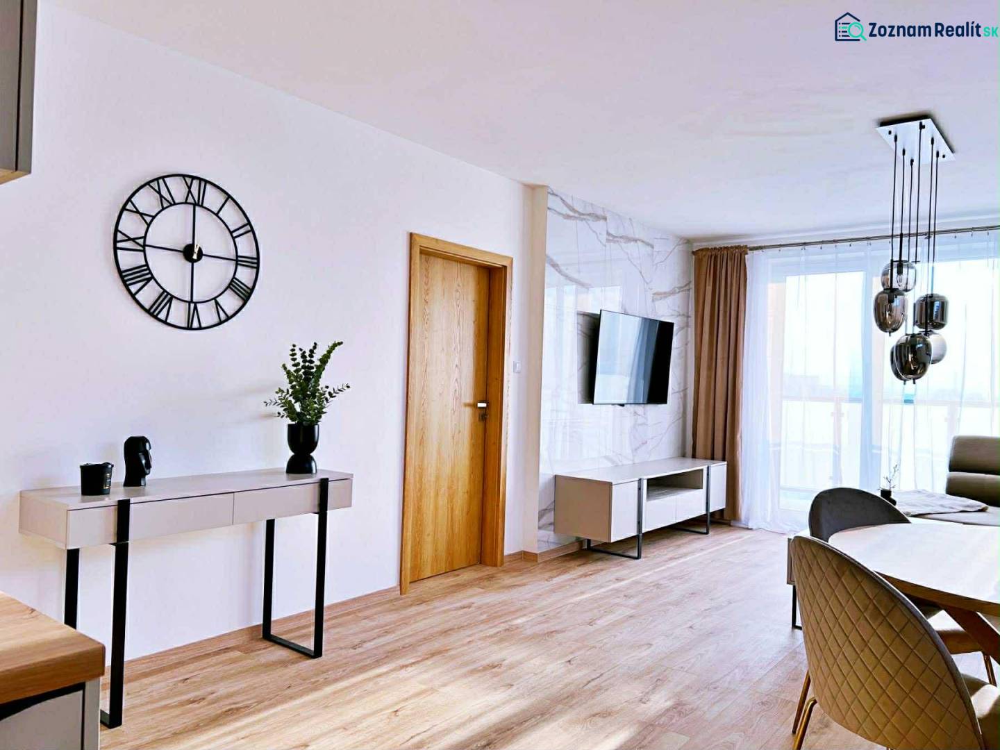 NADŠTANDARDNÝ 3-IZBOVÝ BYT NA PRENÁJOM | Byty Solivarská, Prešov - Obývacia izba v 3-izbovom byte s podlahou s dreveným dekorom, stolom a televízorom.