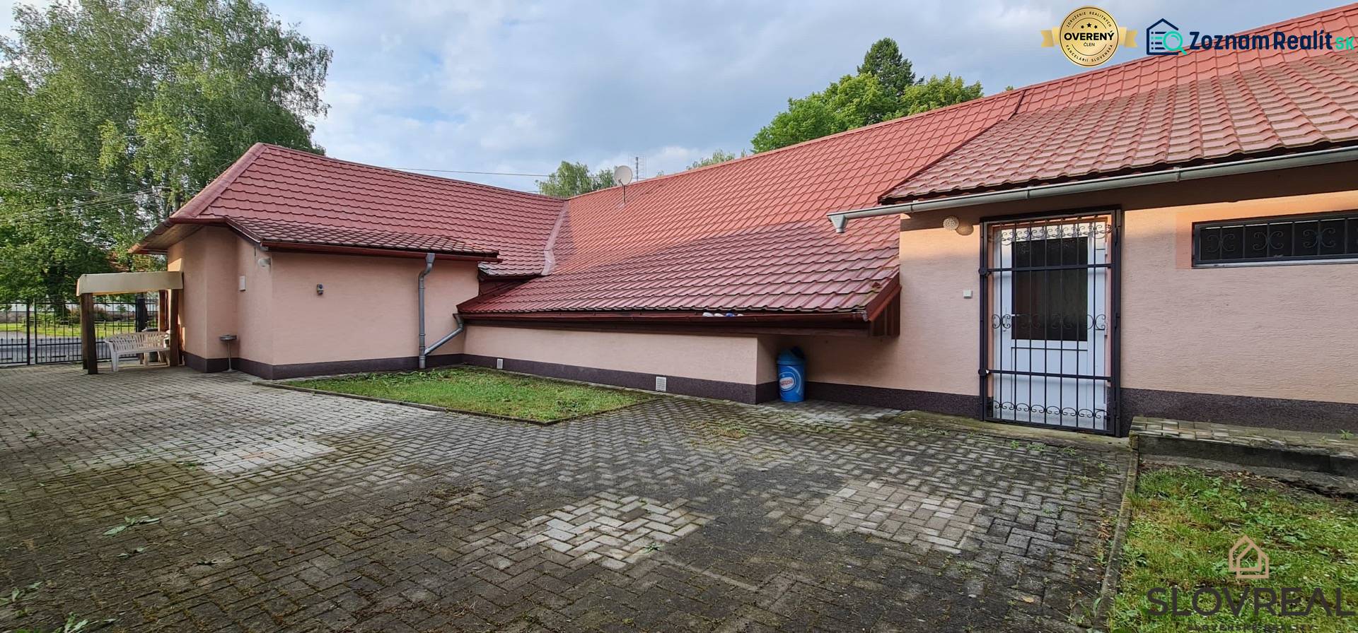 Predaj Domu v obci Lovča - Rodinný dom v Lovči s dlaždeným dvorom a červenou strechou.