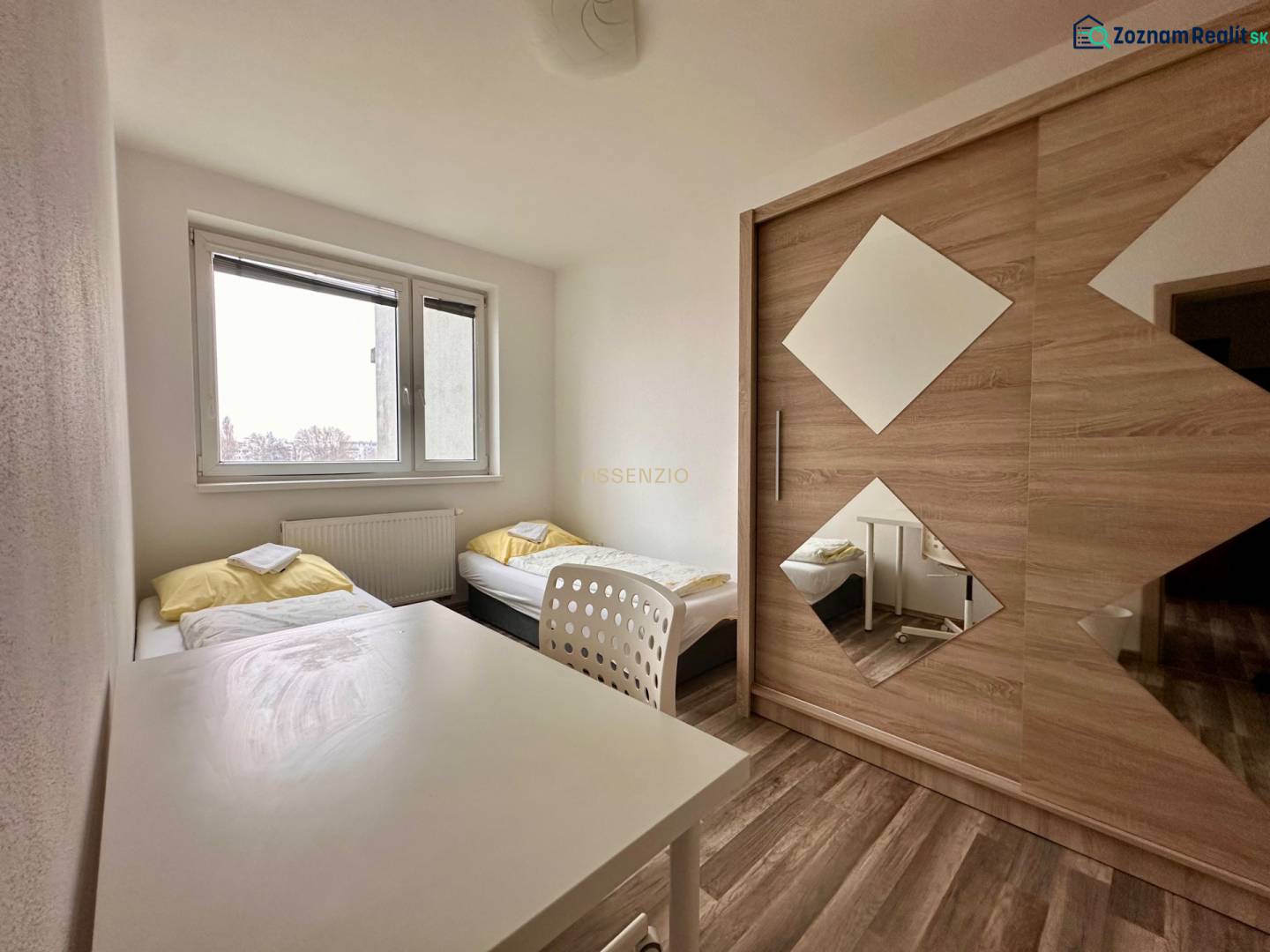 | PREDAJ | 3 izbový byt s veľkou loggiou – Banšelova, Ružinov - Spálňa s dvomi posteľami, bielym stolom a skriňou v 3-izbovom byte.