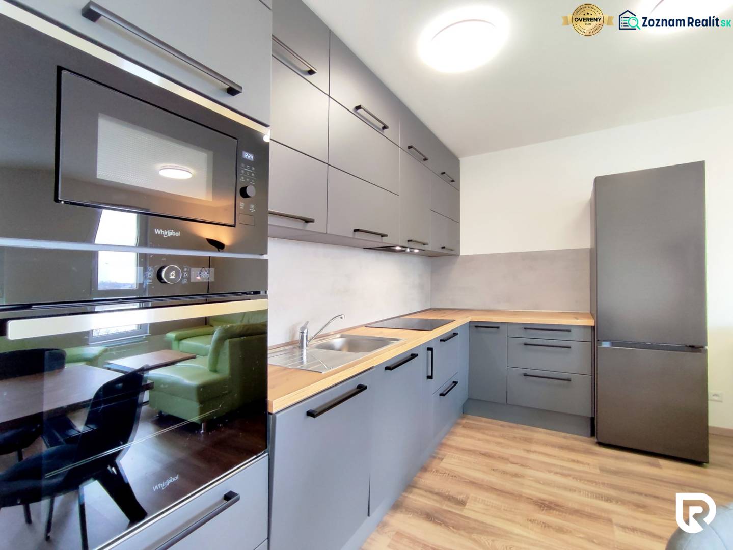 | 3-izbový byt v novostavbe, ul. Odevná + parking | Trenčín  - Kuchyňa v 3-izbovom byte s podlahou s dreveným dekorom, šedé skrinky, vstavané spotrebiče.