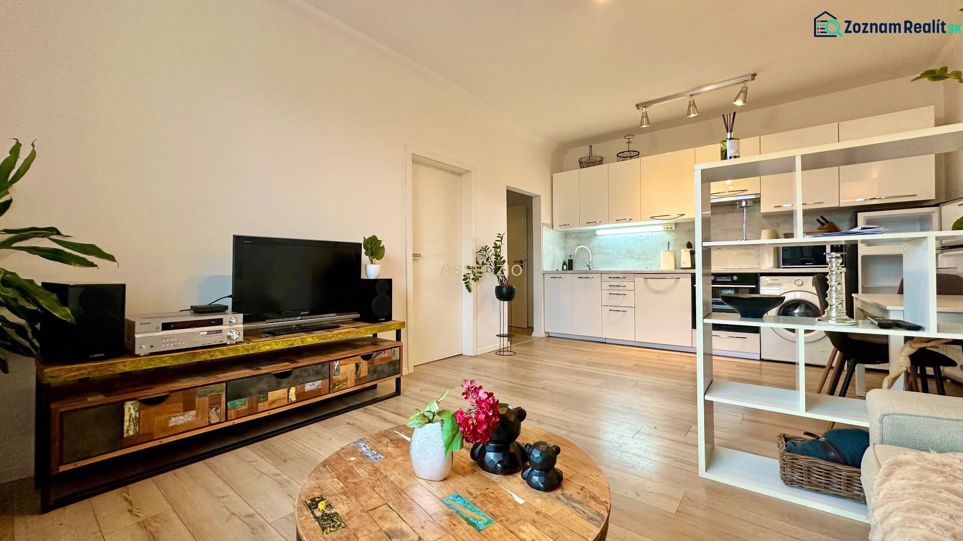 – PRENAJOM – 2 IZBOVÝ BYT 52 m² – OSTREDKOVA – RUŽINOV  - Obývačka v 2-izbovom byte s podlahou s dreveným dekorom, vkusne zariadená a útulná.