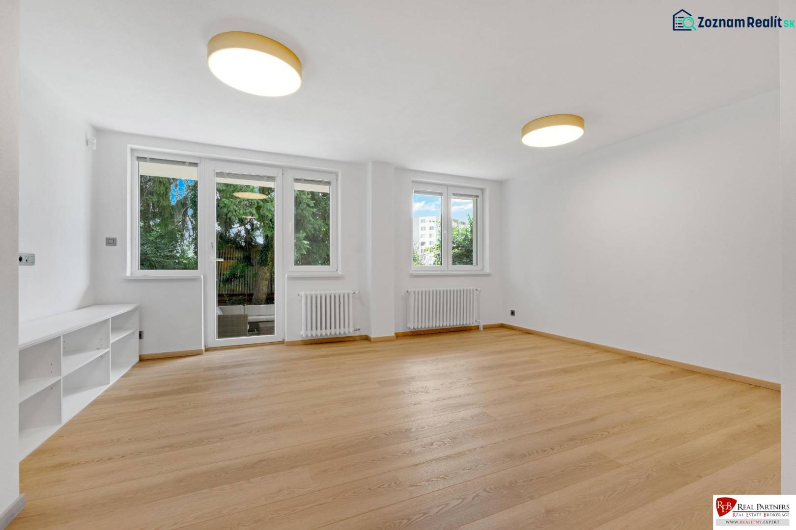 ,Prenájom moderný 3 izb. dom, Sološnícka ul,124 m2, Karlova Ves - Obývacia izba s podlahou s dreveným dekorom v rodinnom dome, presvetlená izbovými oknami.