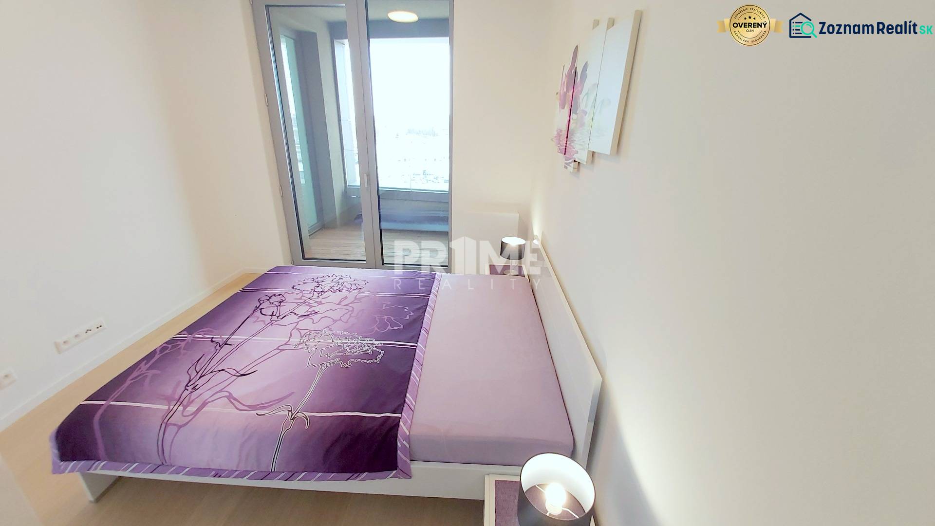 JEDINEČNÝ 2i byt, NOVOSTAVBA, KLÍMA, VÝHĽAD, PARKING, SKY PARK - Posteľ s fialovým povlečením, stolík a lampa v 2-izbovom byte.